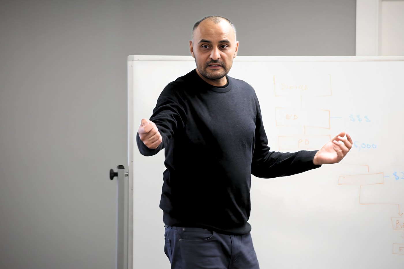Khawar Zaman mid-explanation at a whiteboard in Edmonton