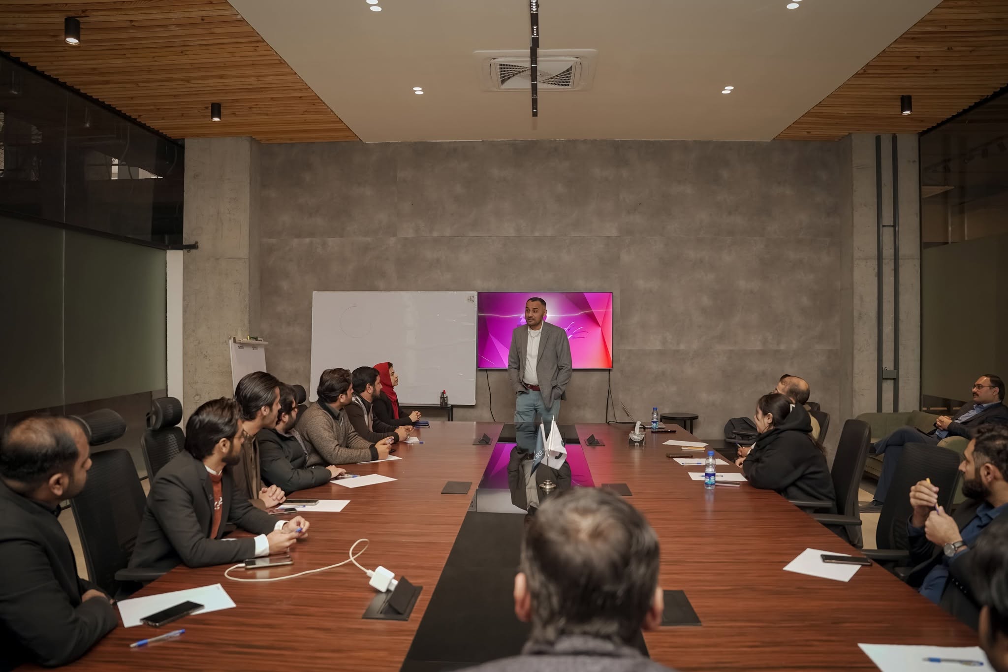 Khawar presenting to executives seated around a boardroom table